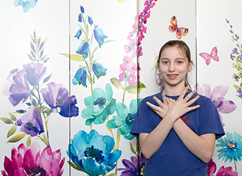 Girl with autism using Makaton to sign the word butterfly