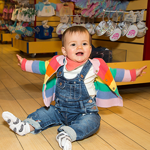 Cheerful baby wearing a colourful stripy cardigan