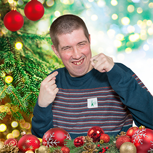 Cheerful young man surrounded by Christmas baubles
