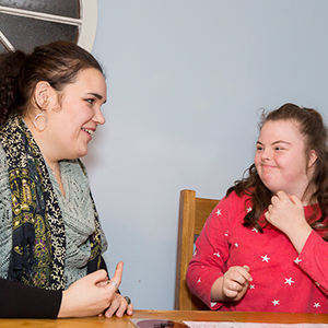 Young woman talking with a teenage girl, who has Down's syndrome